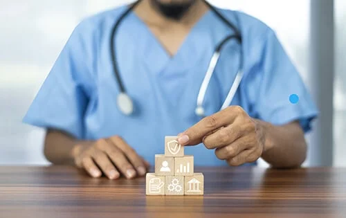 Medico edificando un plan con bloques de madera.